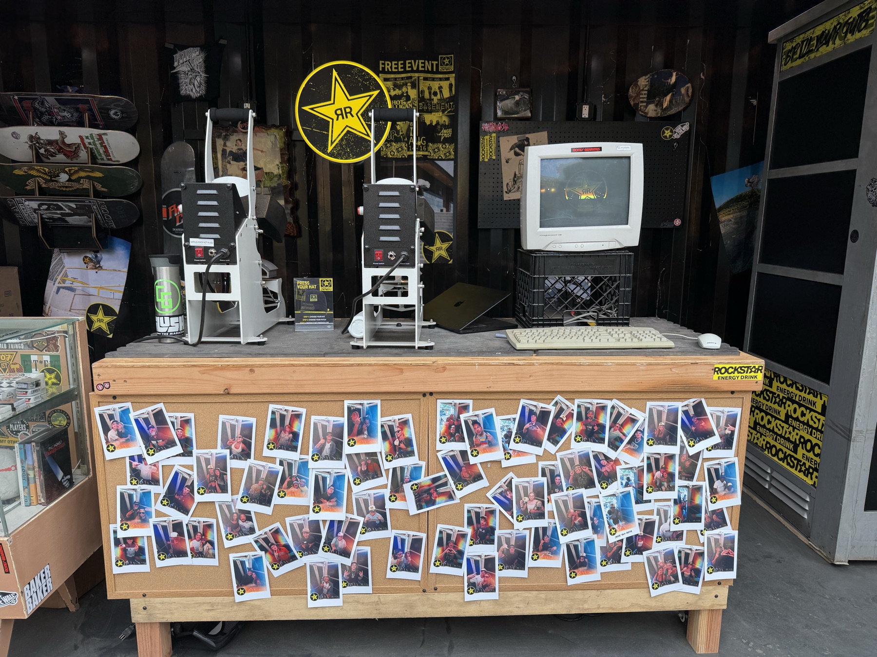 The registration desk with a CRT monitor, old keyboard and mouse, and a growing collection of printed portraits.