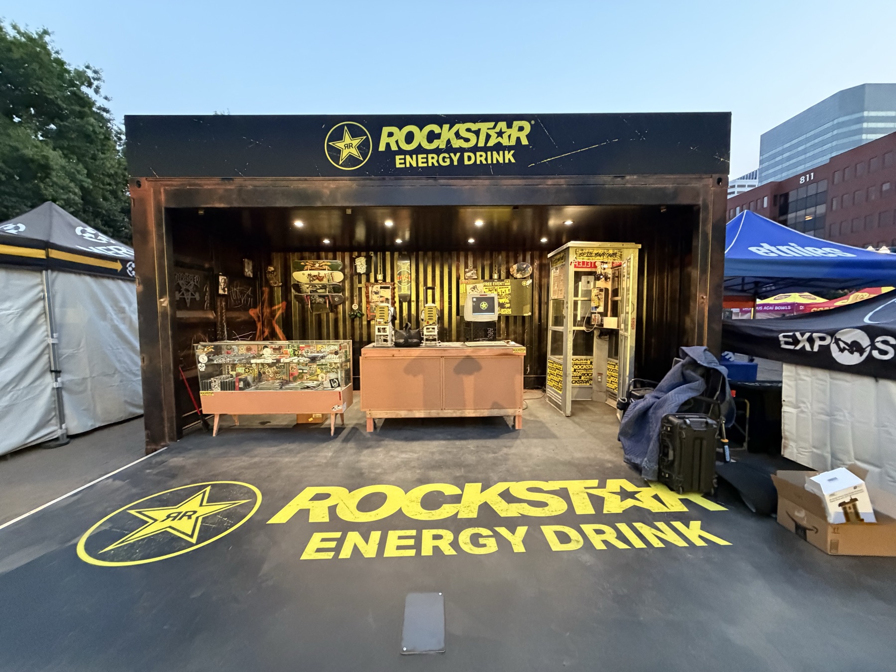 The full Rockstar Energy installation at dusk, with display cases, registration desk, and payphone booth.